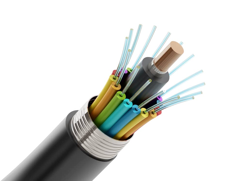 Sección transversal de un cable de fibra óptica mostrando múltiples fibras de colores dentro de una funda protectora.